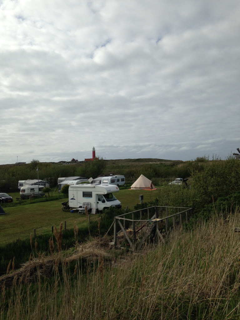 Onze tent tussen de caravans en op de achtergrond de vuurtoren.