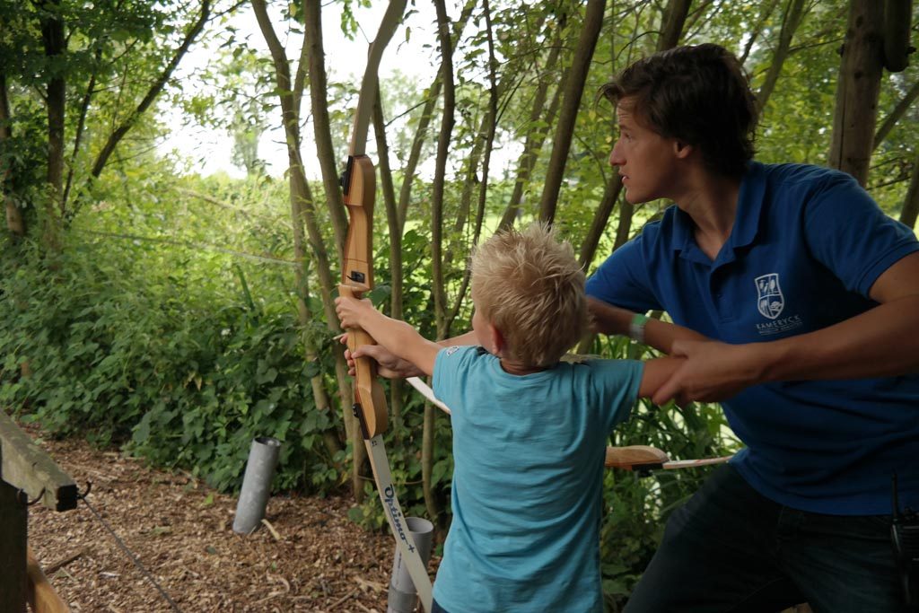 Onder begeleiding van een instructeur leren handboogschieten.