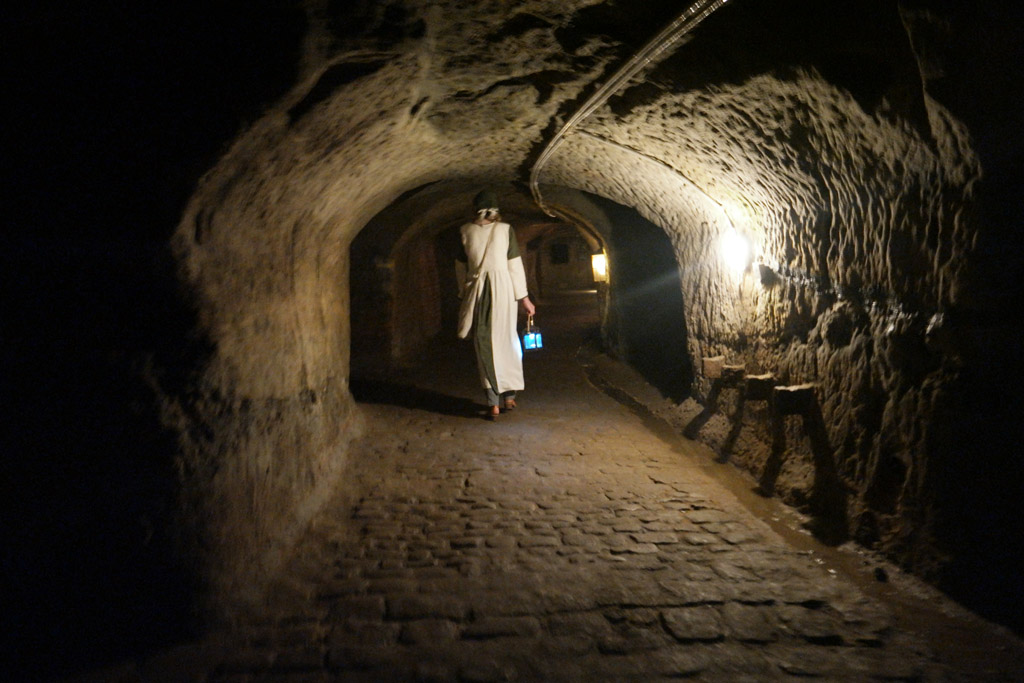 Vrouw Ayrer loopt met haar lantaarn voorop.