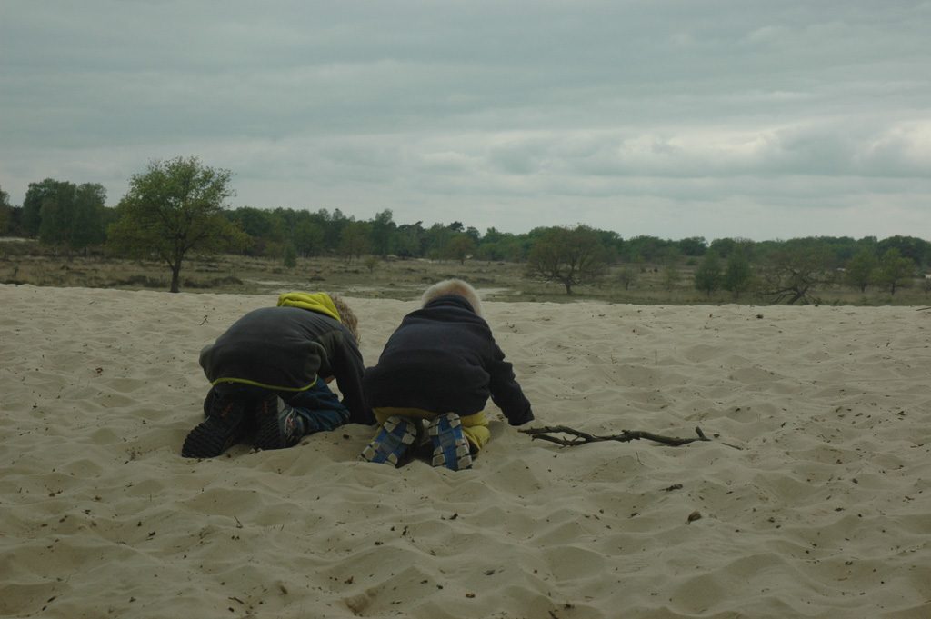 Spelen met zand in de grote zandbak.