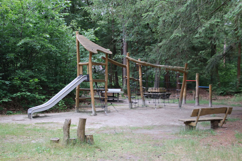 Deze speeltuin vind je in het bos op het park