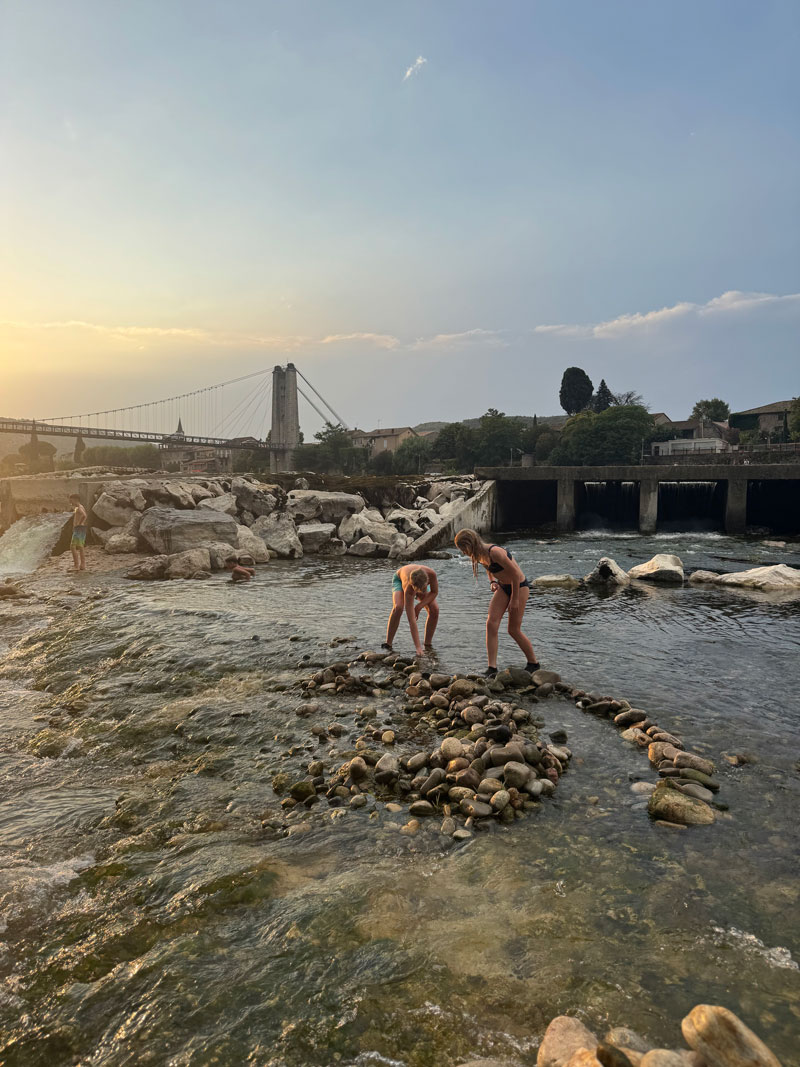 Kinderen aan een strandje langs de rivier tijdens de eenoudervakantie in de Ardèche
