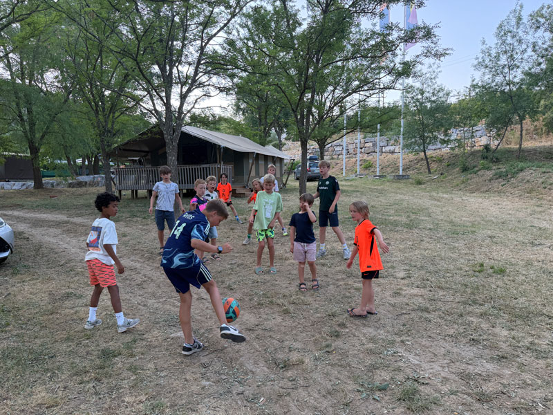 Kinderen voetballen samen tijdens het activiteitenprogramma van Estivant
